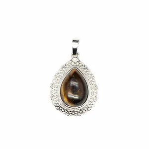 Macro view of teardrop natural gemstone pendant with vintage silver filigree lace border