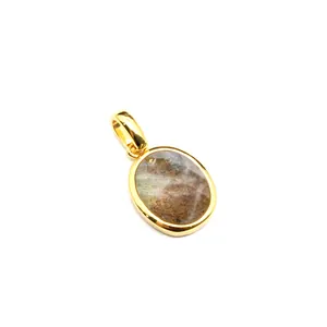 Detailed close-up of a small oval faceted natural stone pendant with gold bezel setting
