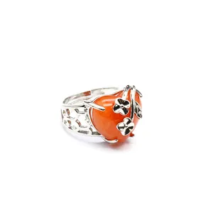 Detail view of silver open ring with orange heart stone and floral vine design