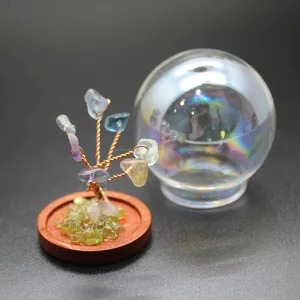 Close-up of a miniature crystal tree of life with a decorative glass dome on wooden base