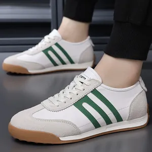 Detailed close-up view of men's white retro sneakers with green stripes and gum sole