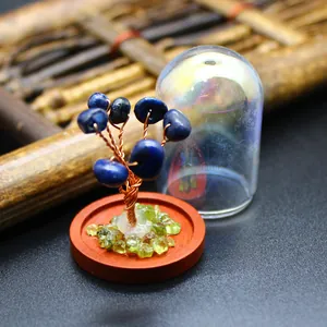 Close-up detail of miniature gemstone tree of life with glass dome on a wooden base