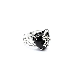 Detail view of an adjustable silver ring with black heart stone and rose flower decor.