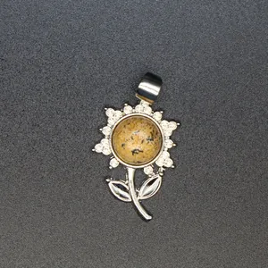 Nahaufnahme eines silbernen Sonnenblumenanhängers mit einem natürlichen Dalmatinerstein