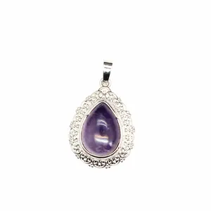 Detailed view of a natural amethyst teardrop pendant with ornate silver filigree border