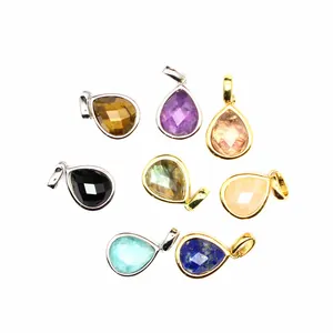 Macro detail of various faceted natural stone teardrop pendants in gold and silver bails