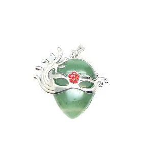 Detail of green teardrop stone pendant with silver masquerade mask and red flower