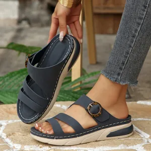 Detail view of navy blue wedge sandals with decorative buckle and thick sole
