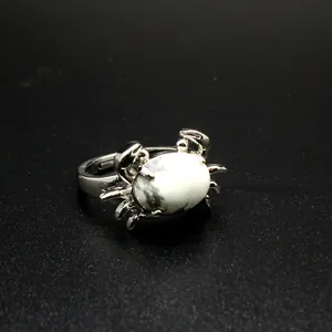 Detailansicht eines kreativen silbernen Krabbenrings mit einem polierten weißen Marmorstein.