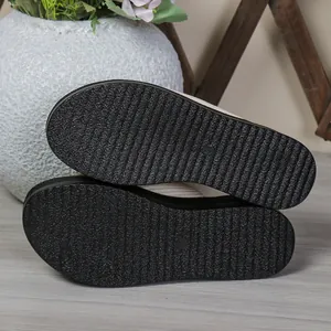 Bottom view of black platform slide sandals showing non-slip textured outsole pattern