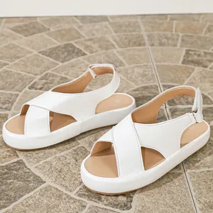 Détail de sandales à plateforme blanches avec des brides croisées et bride arrière