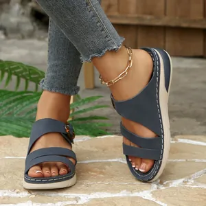 Detail view of navy blue wedge sandals for women with thick soles and buckle details.