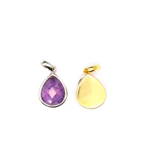 Macro detail view of teardrop faceted purple crystal pendant with gold-plated metal back