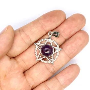 Detail van een zilveren pentagram hanger met een paarse amethist steen in de hand