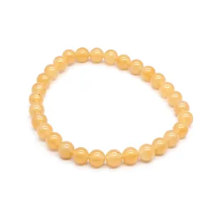 Detail view of a 6mm natural yellow stone beaded bracelet on white background