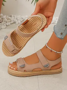 Dettaglio sandali beige con zeppa, suola in corda intrecciata e cinturini a strappo.