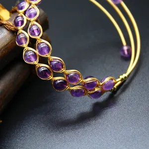 Détail en gros plan de perles d'améthyste violettes serties de fil d'or sur bracelet 3 rangs