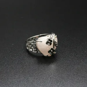 Detailed macro view of the silver rose and flower motifs on a pink heart crystal ring