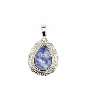 Detailed view of a teardrop pendant with blue sodalite stone and ornate filigree edging.