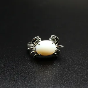 Detaillierte Nahaufnahme eines silbernen Rings in Krabbenform mit weißem Opal-Inlay-Schmuck