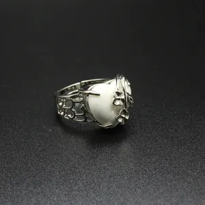 Macro detail of heart-shaped white stone ring with intricate silver flower accents