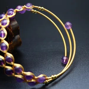 Gros plan d'un bracelet triple rang plaqué or avec perles d'améthyste violettes