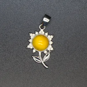 Makro-Detail des silbernen Sonnenblumen-Anhängers mit gelbem Edelstein und Kristallen