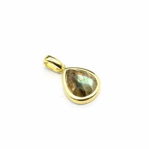 Detail showing a teardrop-shaped natural stone pendant with a polished gold-tone finish.