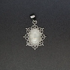Close-up detail of a vintage silver filigree pendant with an oval white natural stone