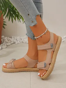 Dettaglio di sandali beige con plateau, suola intrecciata e cinturini in velcro