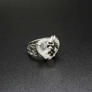 Detailed macro view of a vintage silver heart crystal ring with intricate flower motifs.