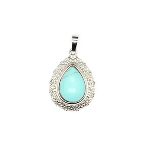 Detailed close-up of a teardrop-shaped turquoise pendant with vintage silver lace border