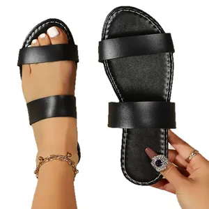Minimalist black double-strap flat sandals with soft sole for beach and casual wear.