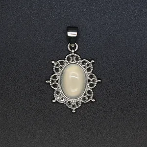 Detailed macro view of an oval natural stone pendant with intricate silver filigree border