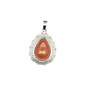 Detailed macro view of an ornate silver teardrop pendant with a shimmering goldstone center.
