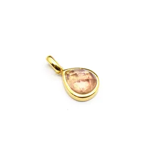 Macro detail of a faceted teardrop natural stone pendant in a gold-plated setting