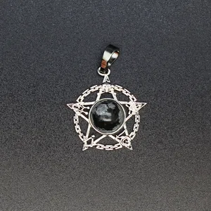 Detailopname van een zilveren pentagram hanger met occulte symbolen en zwarte steen.