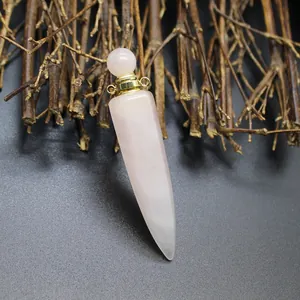 Detail view of hexagonal rose quartz perfume bottle pendant on rustic branch background