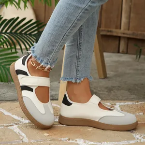 Dettaglio scarpe basse Mary Jane con cinturino in velcro stile sportivo bianco grigio