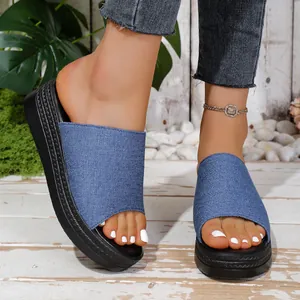 Close-up detail of women's denim platform slides featuring thick soles and casual style