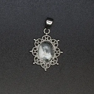 Close-up detail of ornate silver filigree pendant with natural grey marbled stone