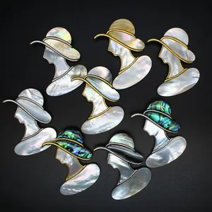 Détail de magnifiques broches et pendentifs en nacre irisée en forme de silhouette de femme