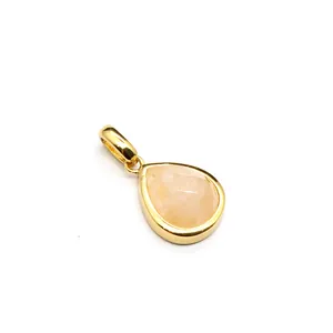 Macro view of a teardrop-shaped faceted natural stone pendant with gold plating