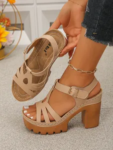 Detailopname van beige plateausandalen met blokhak en open teen.