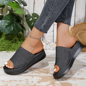 Detailed side view of casual denim fabric platform slide sandals with thick black soles