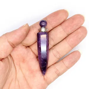 Close-up of a natural amethyst hexagonal cone perfume bottle pendant held in hand