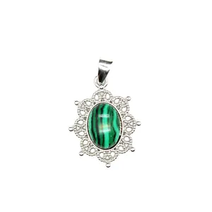 Detail view of an intricate silver filigree pendant with an oval malachite stone
