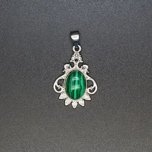 Detailed view of a vintage silver malachite pendant with intricate scrollwork and crystals
