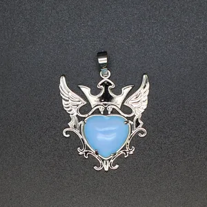 Vista detallada de un colgante de piedra azul con forma de corazón, corona y alas de plata