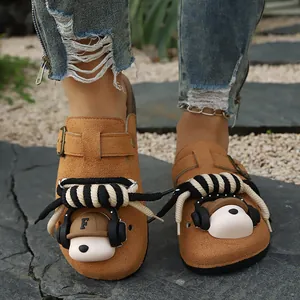Close-up of brown suede platform clogs with cute headphone bear and rope charms.